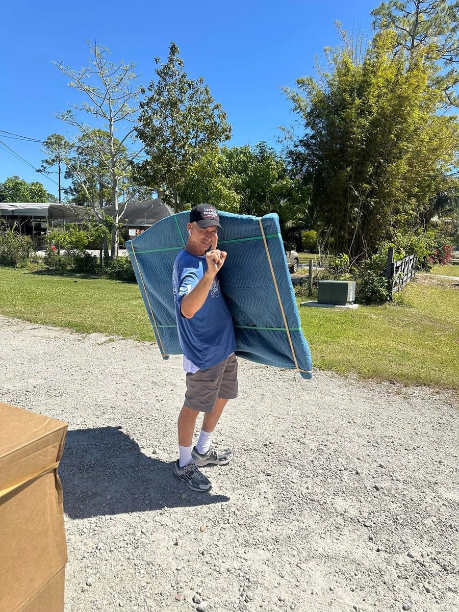 A Central Florida Pros mover carrying a padded piece